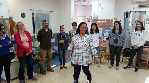 מורה רוקדת וצוחקת במהלך סדנת אקו