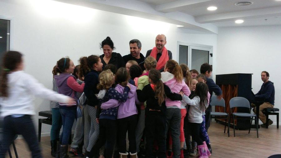 חיבוק קבוצתי של ילדים עם צוות השחקנים בסיום המופע