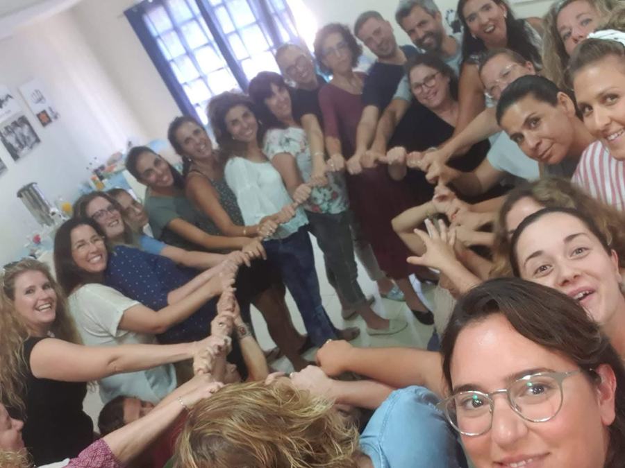 צוות ארגון יוצר שרשרת ידיים בתרגיל גיבוש