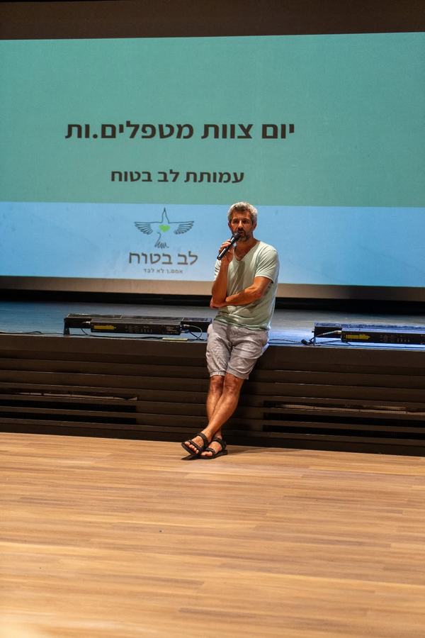 מנחה מרצה על הבמה ביום צוות מטפלים, עמותת לב בטוח