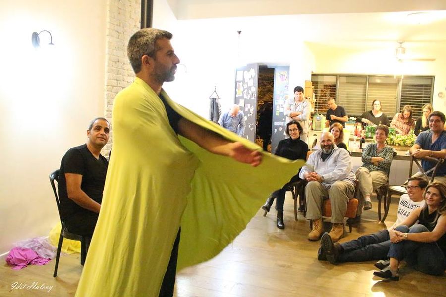 שחקן במחול עם גלימה צהובה מול קהל האורחים באירוע משפחתי